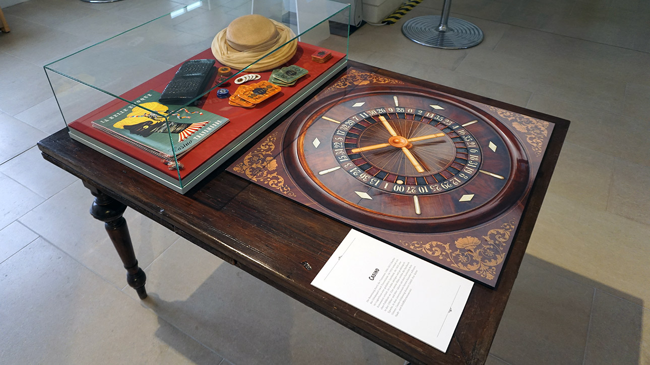 Blick auf einen Glaskasten mit Ausstellungsobjekten aus einem alten Casino.