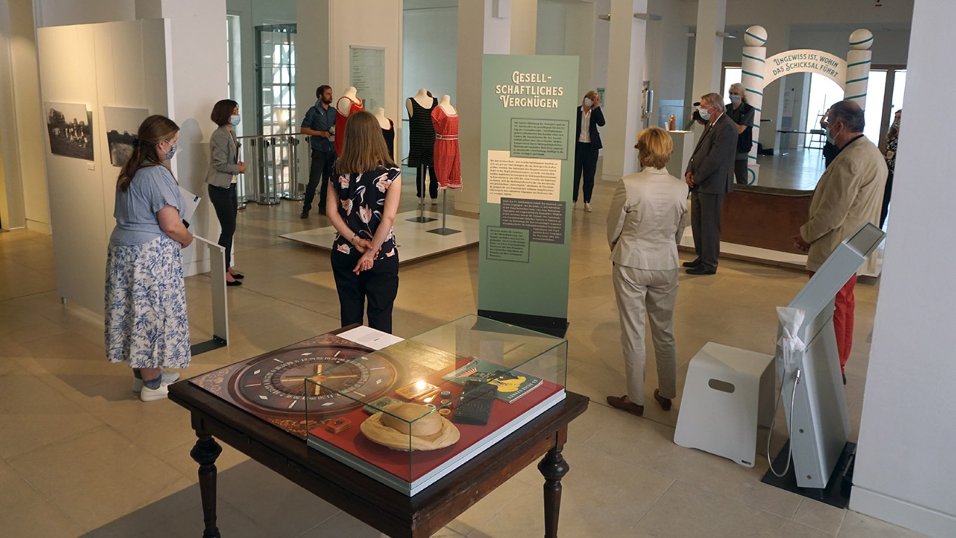 Menschen schauen sich eine Ausstellung über Seebäderkultur in Schleswig-Holstein im Landeshaus an.