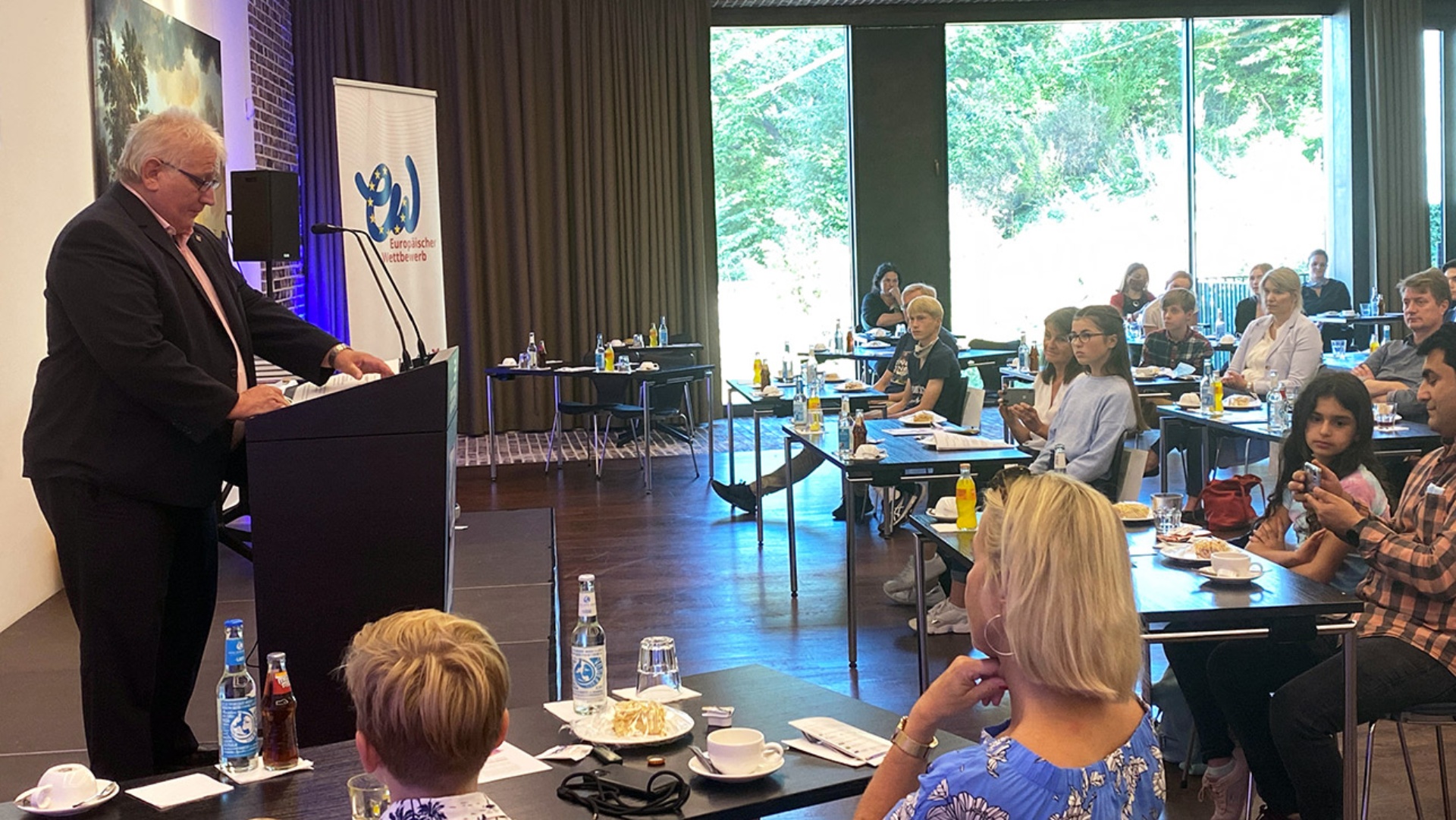 Landtagspräsident Klaus Schlie hält vor Kindern und Eltern eine Rede.