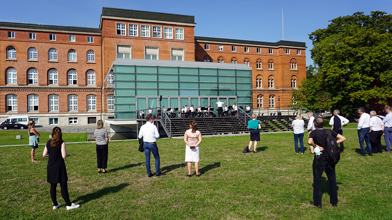 Zuschauer lauschen einem Konzert des Marinemusikkorps vor dem Landeshaus in Kiel.