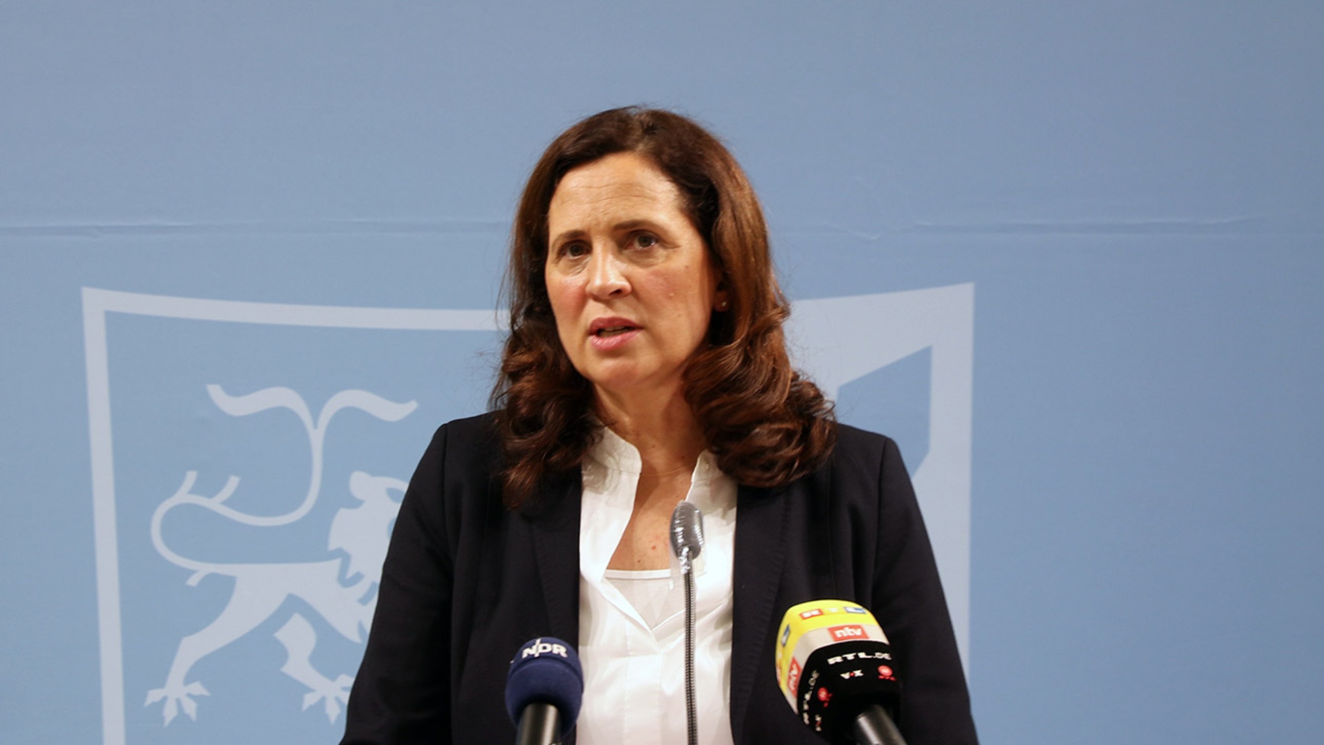 Die Landesbeauftragte Samiah El Samadoni stellt auf einer Pressekonferenz ihren Tätigkeitsbericht zur Beschwerdestelle für Kinder und Jugendliche vor. Vor ihr sind zwei Mikrofone aufgebaut.