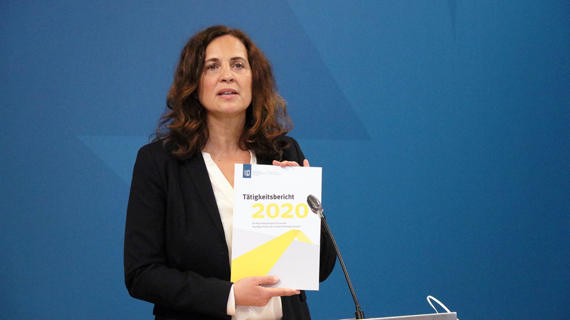 Die Bürgerbeauftragte Samiah El Samadoni hält bei einer Pressekonferenz ihren neuen Tätigkeitsbericht hoch.