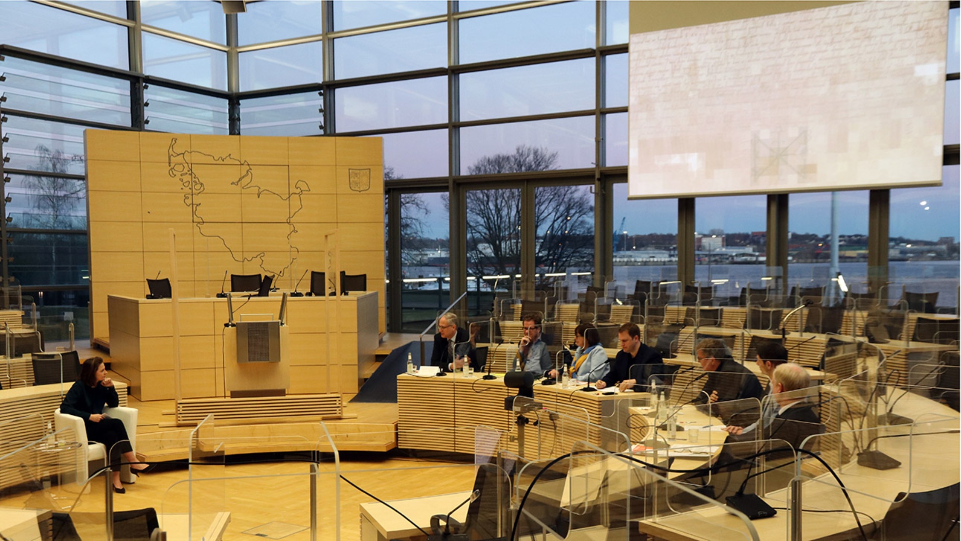 Im Plenarsaal des Landtages sitzen Menschen. 