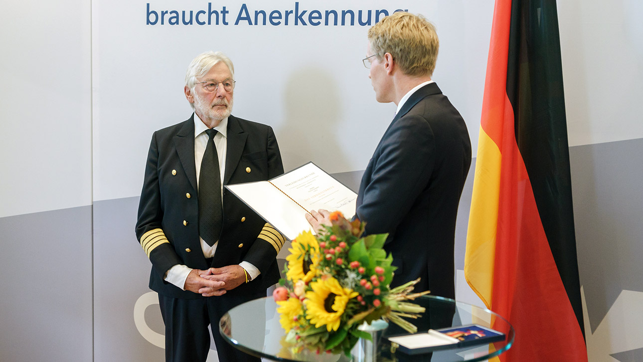 Ministerpräsident Daniel Günther (CDU) händigt Stefan Schmidt  das Verdienstkreuz am Bande des Verdienstordens der Bundesrepublik Deutschland (Bundesverdienstkreuz) aus.