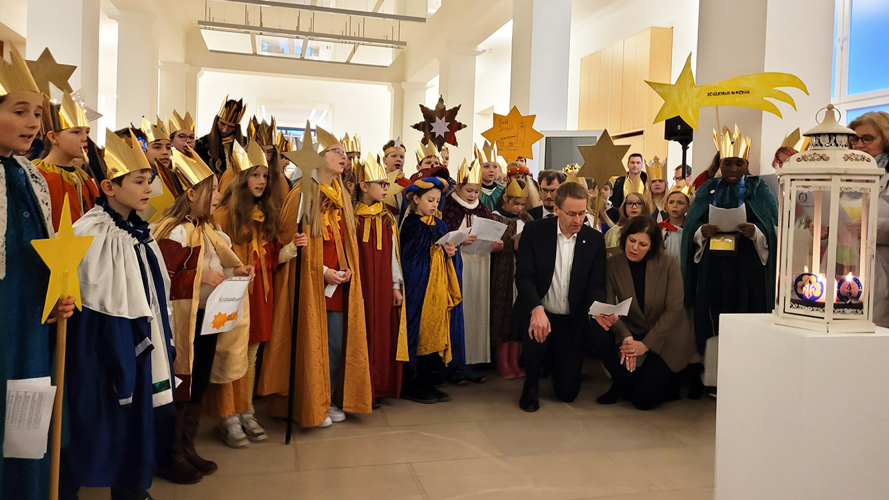 Gemeinsam mit Landtagspräsidentin Kristina Herbst und Ministerpräsident Daniel Günther (CDU) singen die Sternsinger ein Lied in der Halle des Parlaments.