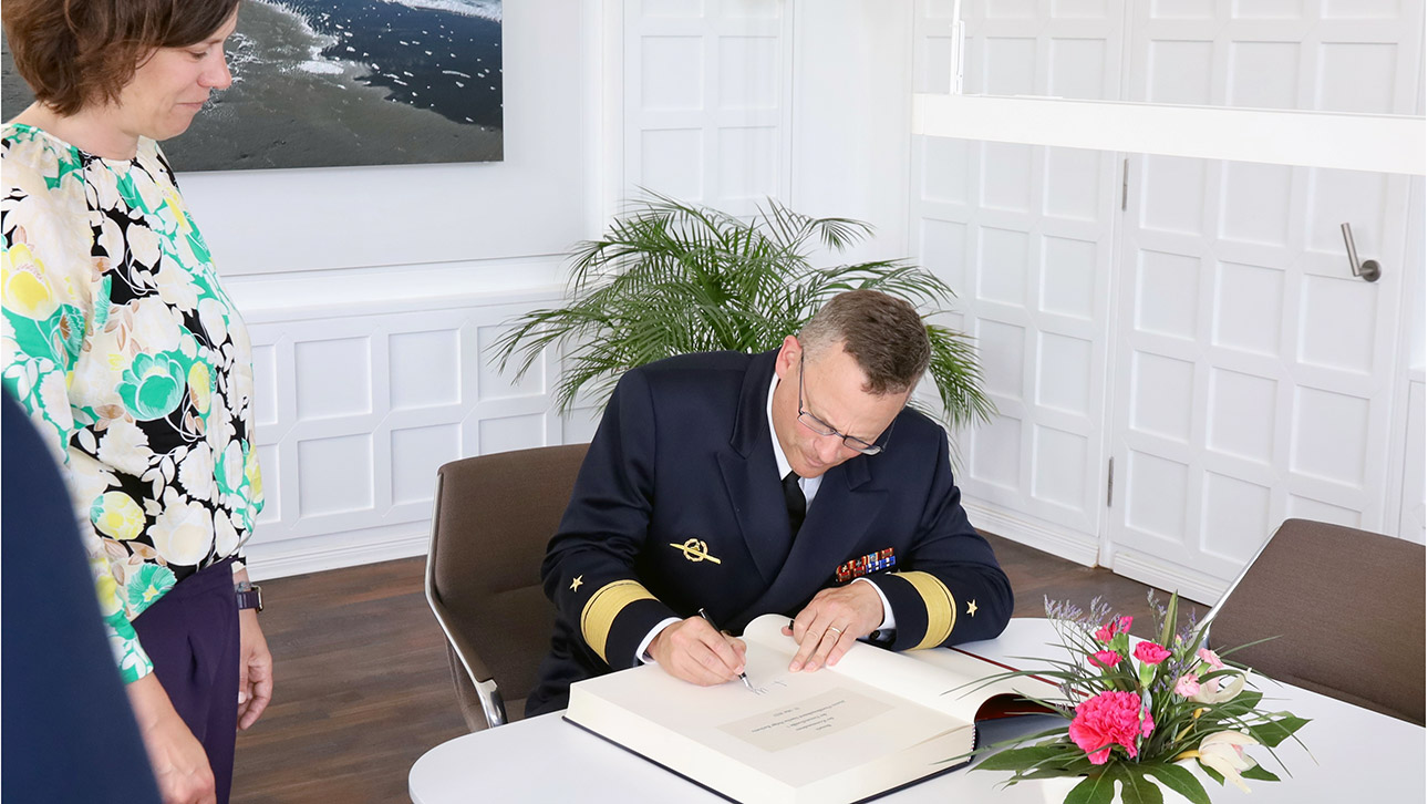 Im Beisein von Präsidentin Kristina Herbst trägt sich Flottillenadmiral Sascha Helge Rackwitz in das Gästebuch des Landtages ein.