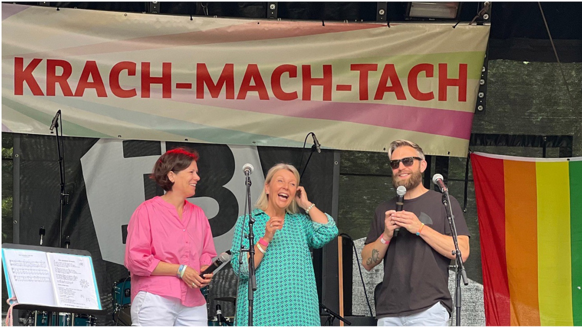 Landtagspräsidentin Kristina Herbst und die Behindertenbeauftragte  Michaela Pries stehen mit Moderator Philipp Jeß auf der Bühne beim Krach-Tach-Tag auf der Kieler Woche.