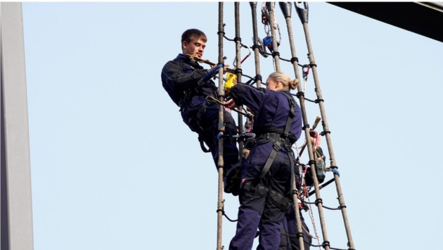 Mitglieder der „Gorch Fock“-Besatzung erneuern in luftiger Höhe das Unterwant vor dem Landeshaus