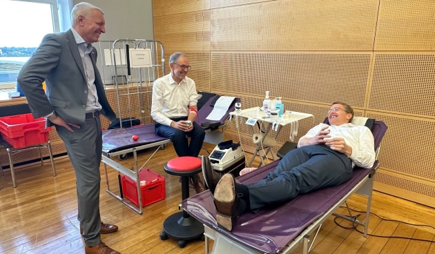 Daniel Günther spendet Blut. Landtagspräsident Peter Lehnert und Ralph Schmieder vom DRK schauen zu.
