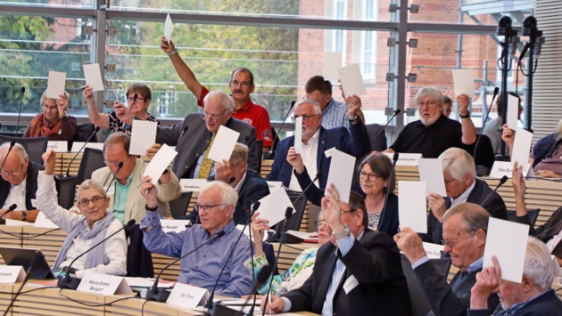 Delegierte des Altenparlaments halten im Plenarsaal des Schleswig-Holsteinischen Landtages bei einer Abstimmung weiße Stimmkarten hoch.
