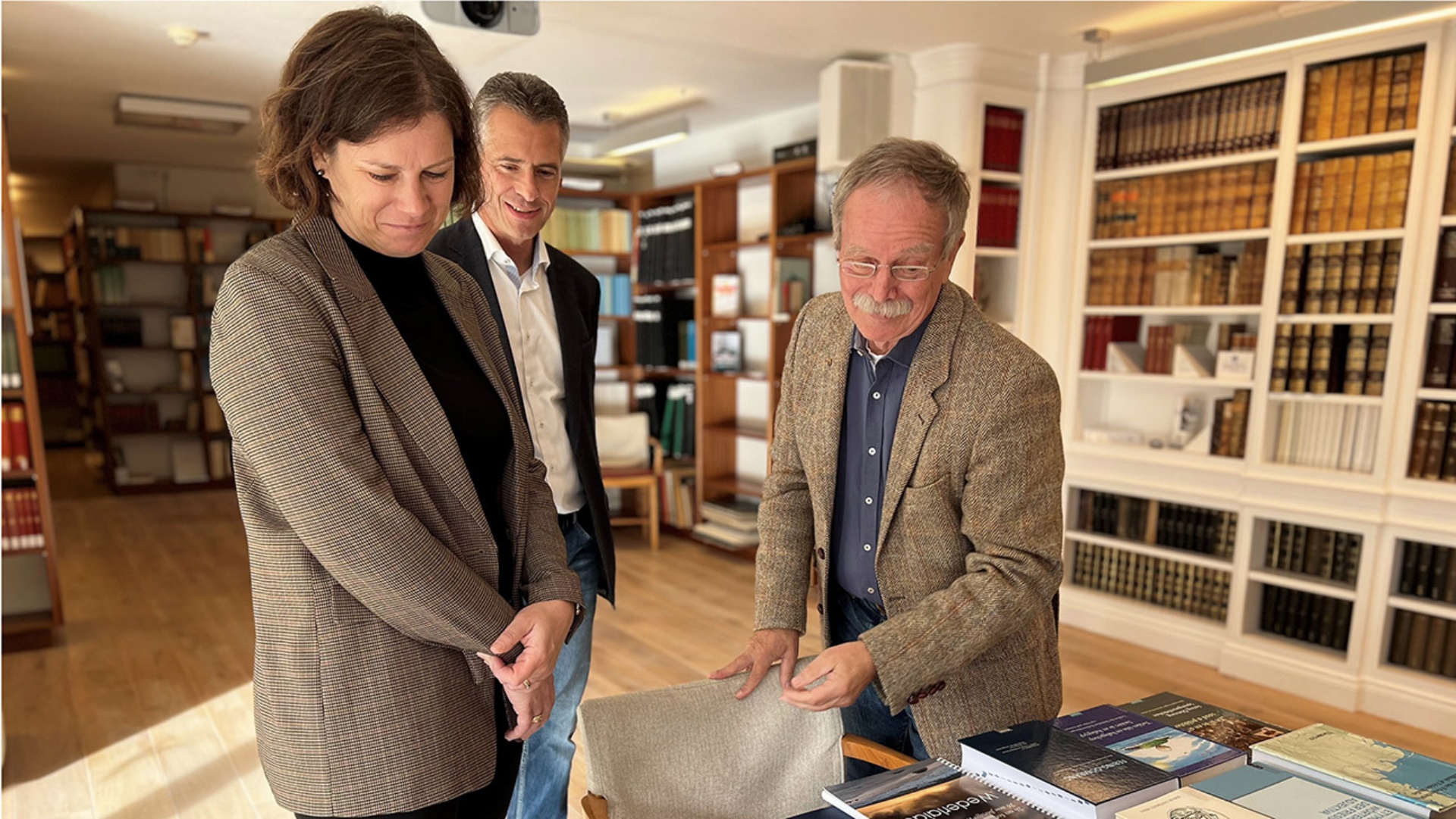Prof. Dr. Volkert Faltings, Vorsitzender Ferring-Stiftung, zeigt Landtagspräsidentin Herbst und Landtagsdirektor Schliesky Bücher der Stiftung 