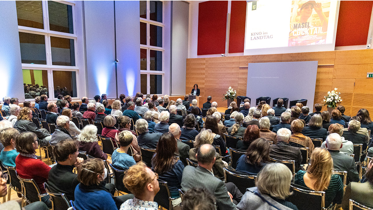 Rund 150 Zuschauer sitzen im vollbesetzten, zum Kino umfunktionierten Schleswig-Holstein.Saal des Landtages.