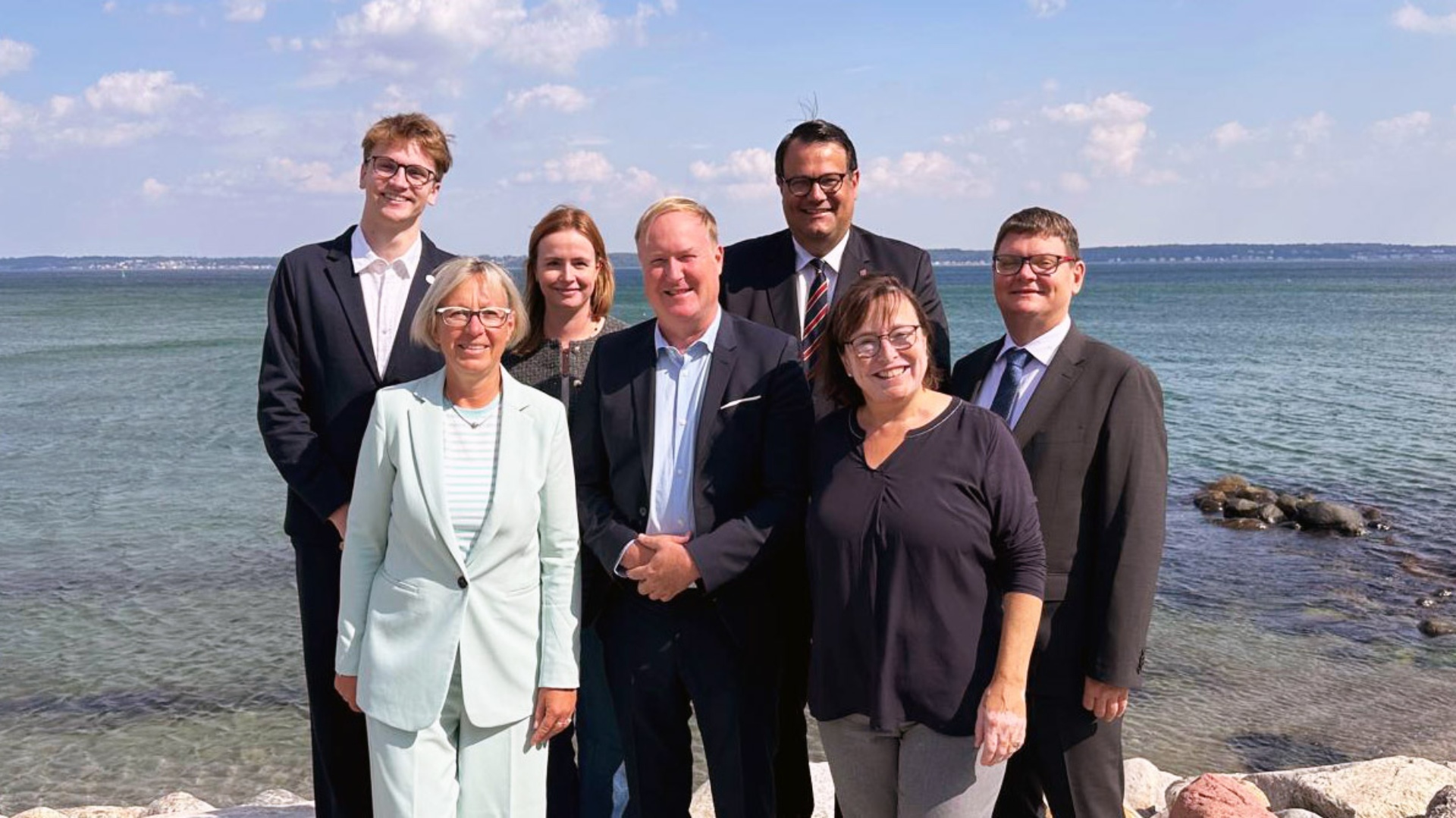 Gruppenfoto bei strahlendem Sonnenschein am Meer mit den Vertretern aus Schleswig-Holstein  (v.re.): Jan Diedrichsen (Leiter der Vertretung des Landtages bei der EU in Brüssel), Eka von Kalben (Vizelandtagspräsidentin), Rasmus Vöge (MdL), Marc Timmer (MdL), Gyde Jensen (MdB), Petra Nicolaisen (MdB), Elias A. (Vertreter Jugendforum).