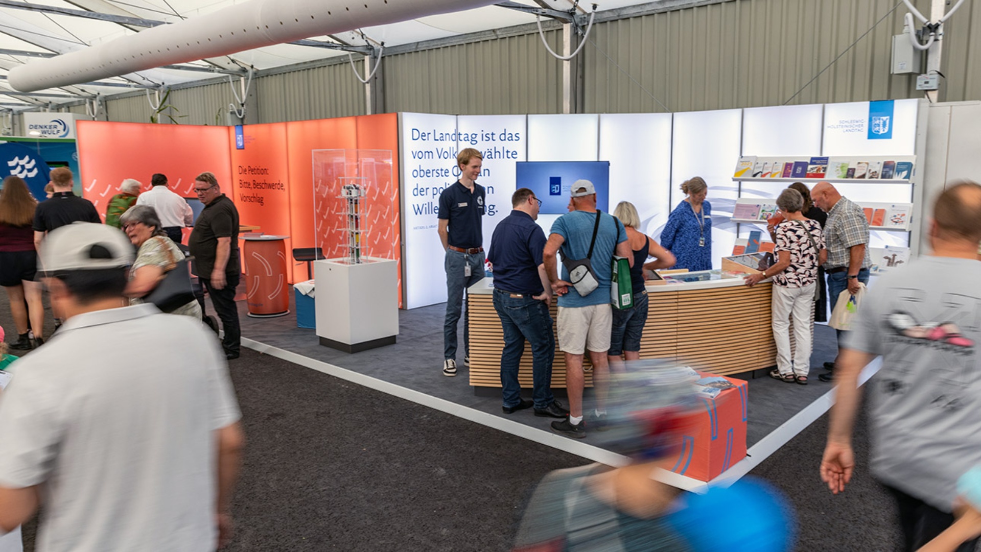 Blick auf den von Menschen umlagerten Messestand des Landtages und des Petitionsausschusses auf der Norla