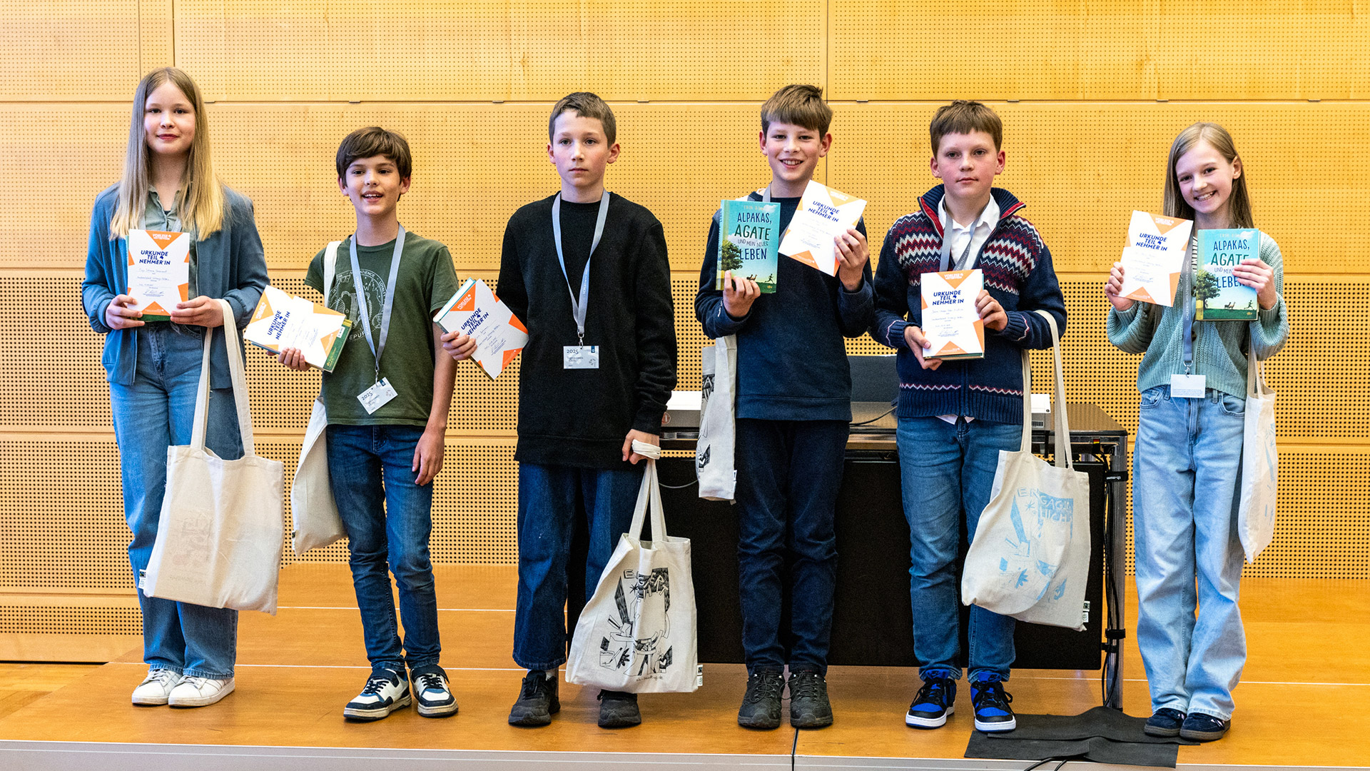 Gruppenfoto der Teilnehmer des Vorlesewettbewerbs mit ihren Lieblingsbüchern und Urkunden