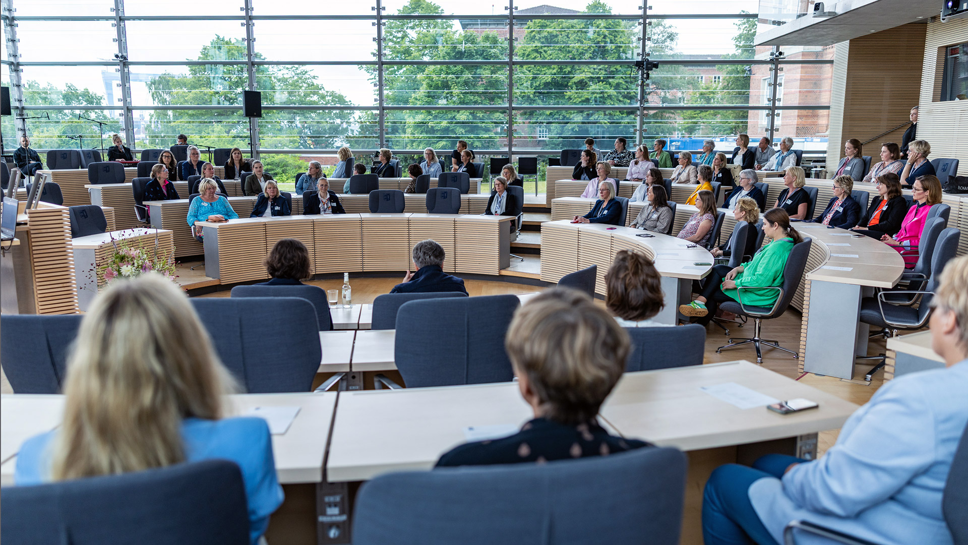 Blick in den Plenarsaal, wo auf den Abgeordnetenplätzen zahlreiche Mandatsträgerinnen sitzen.