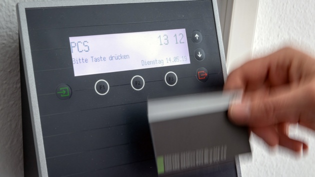 Ein Arbeitnehmer erfasst seine Arbeitszeit digital an einem Terminal.