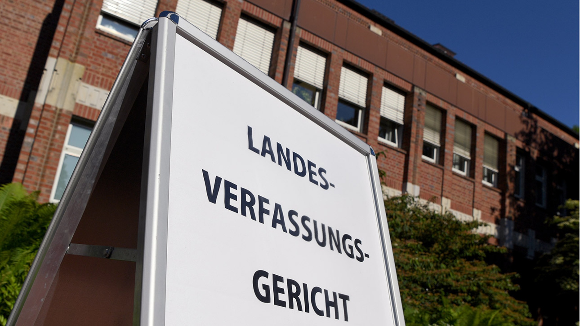 Ein Schild mit dem Hinweis "Landesverfassungsgericht" steht vor dem Gerichtsgebäude in Schleswig.