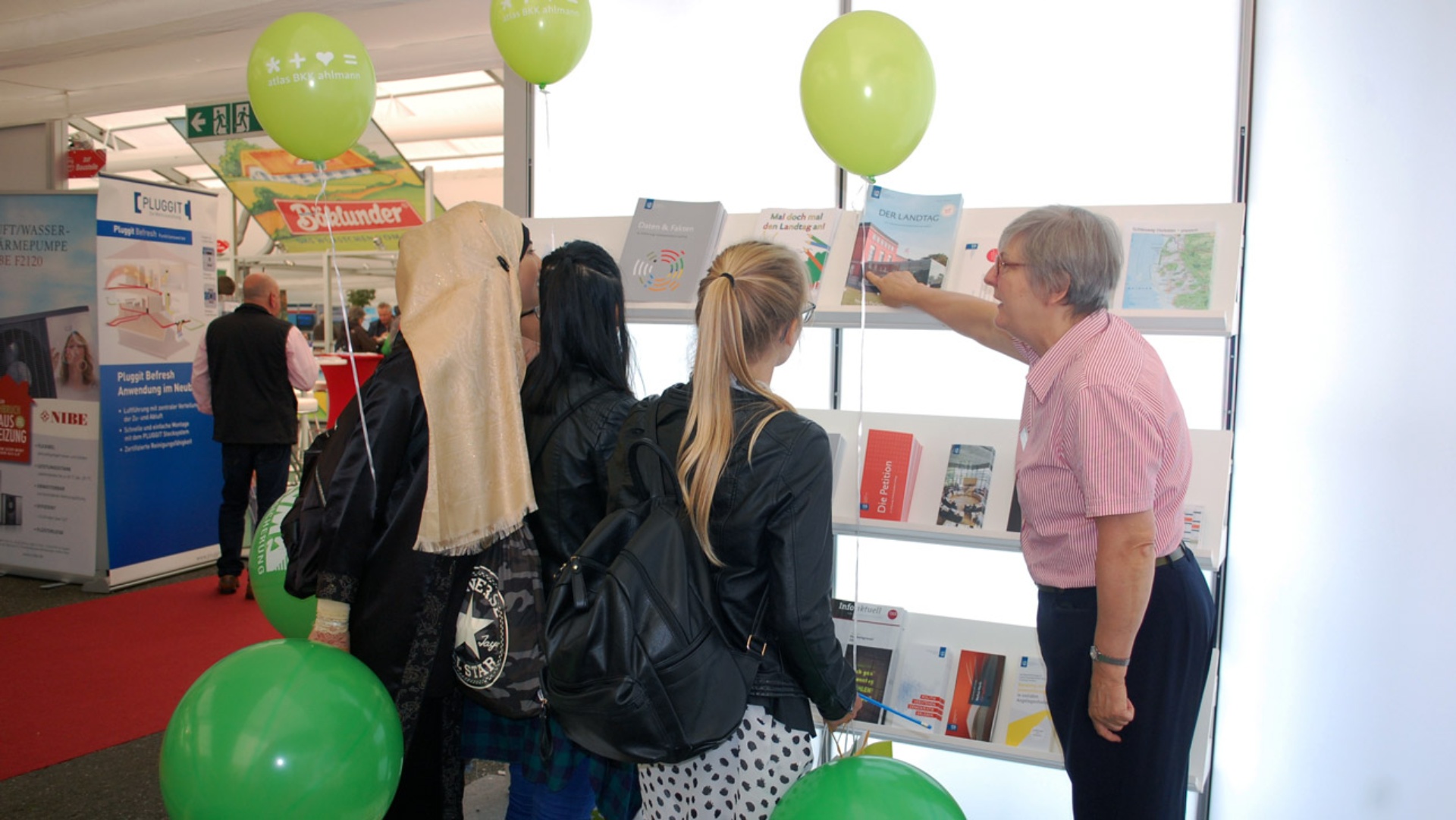 Junge Besucherinnen sehen sich am Stand des Landtages auf der Norla Prospekte an.