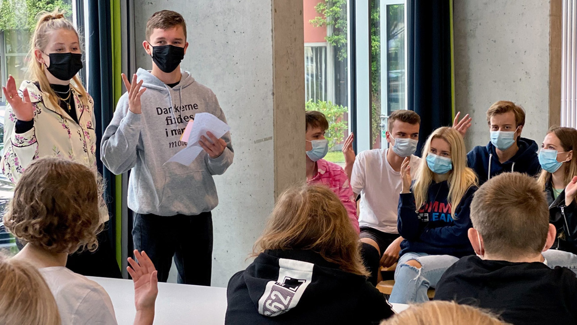 Zwei Schülerbotschafter tauschen sich mit Oberstufenschülern in Bad Schwartau über ihren Alltag in der Grenzregion aus.