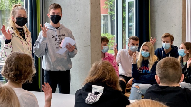 Zwei Schülerbotschafter tauschen sich mit Oberstufenschülern in Bad Schwartau über ihren Alltag in der Grenzregion aus.