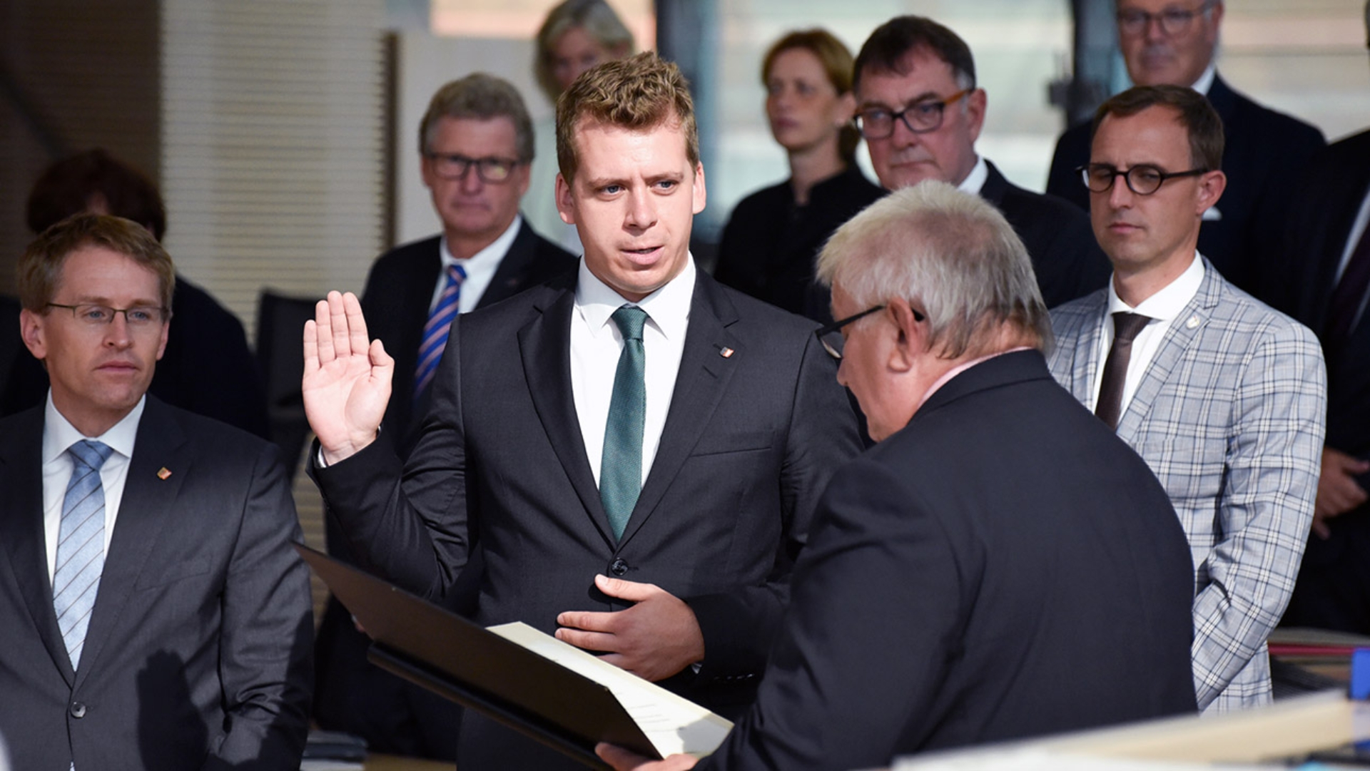 Der Grünen-Abgeordnete Knuth spricht mit zum Schwur hochgebobener Hand die von Landtagspräsident Schlie vorgelesene Eidesformel nach.