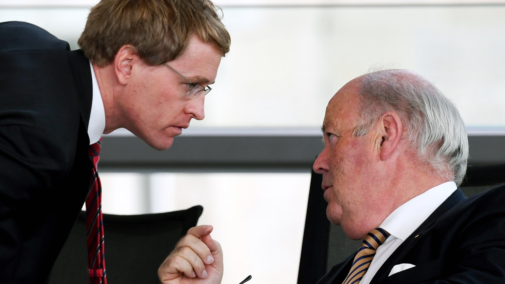 Hans-Joachim Grote und Daniel Günther unterhalten sich im Plenarsaal in den Reihen der Landesregierung.