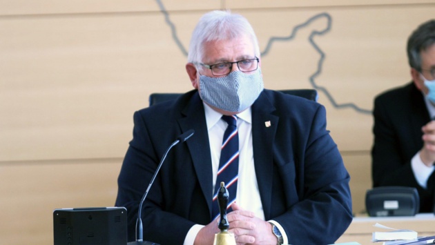 Landtagspräsident eröffnet die Sondersitzung mit einem Mundschutz.