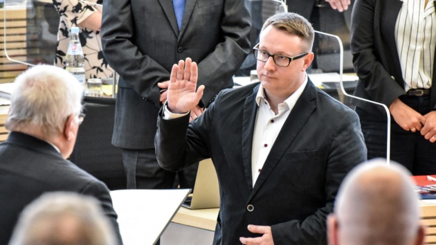 Der SSW-Politiker Christian Dirschauer wird von Landtagspräsident Klaus Schlie verpflichtet. Dirschauer hat den rechten Arm bei der Vereidigung erhoben.