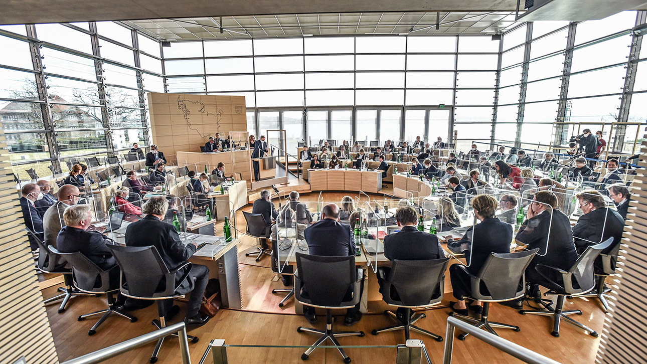 Im Plenarsaal des Schleswig-Holsteinischen Landtages sitzen die Abeordneten im Rund.