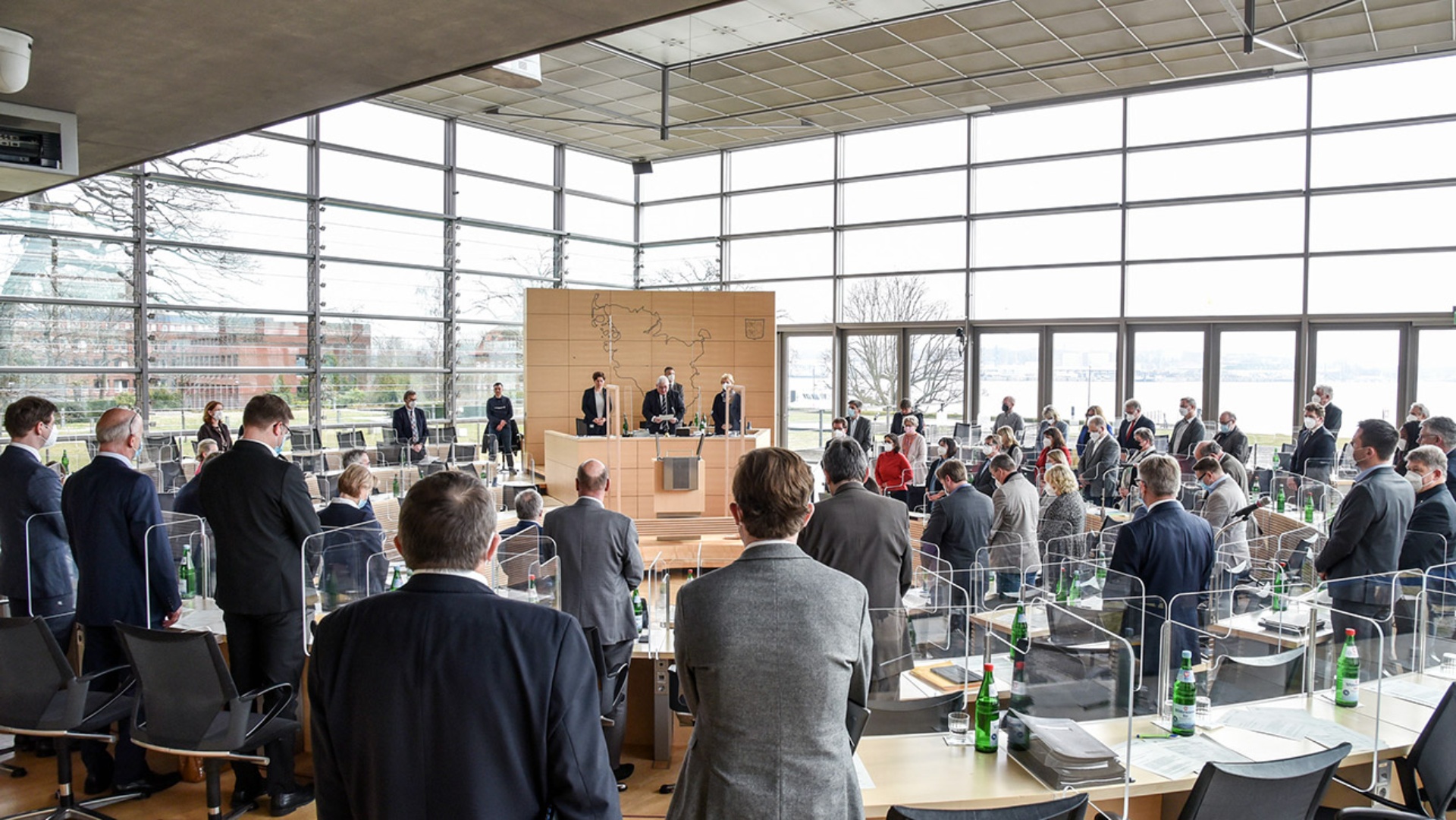 Stehend gedenken die Abgeordneten der Toten der Corona-Pandemie