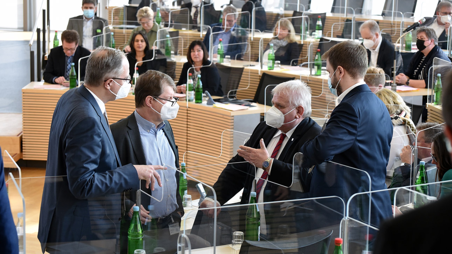 Tobias Koch (CDU), Ralf Stegner (SPD), Klaus Schlie (Landtagspräsident) und Christopher Vogt (FDP) stehen im Plenarsaal des Schleswig-Holsteinischen bei einem Gespräch zusammen.