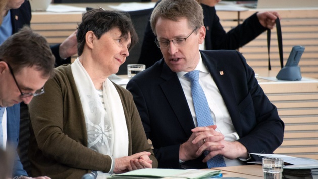 Finanzministerin Monika Heinold (Grüne) und Ministerpräsident Daniel Günther (CDU, re.) unterhalten sich auf der Regierungsbank im Plenarsaal.