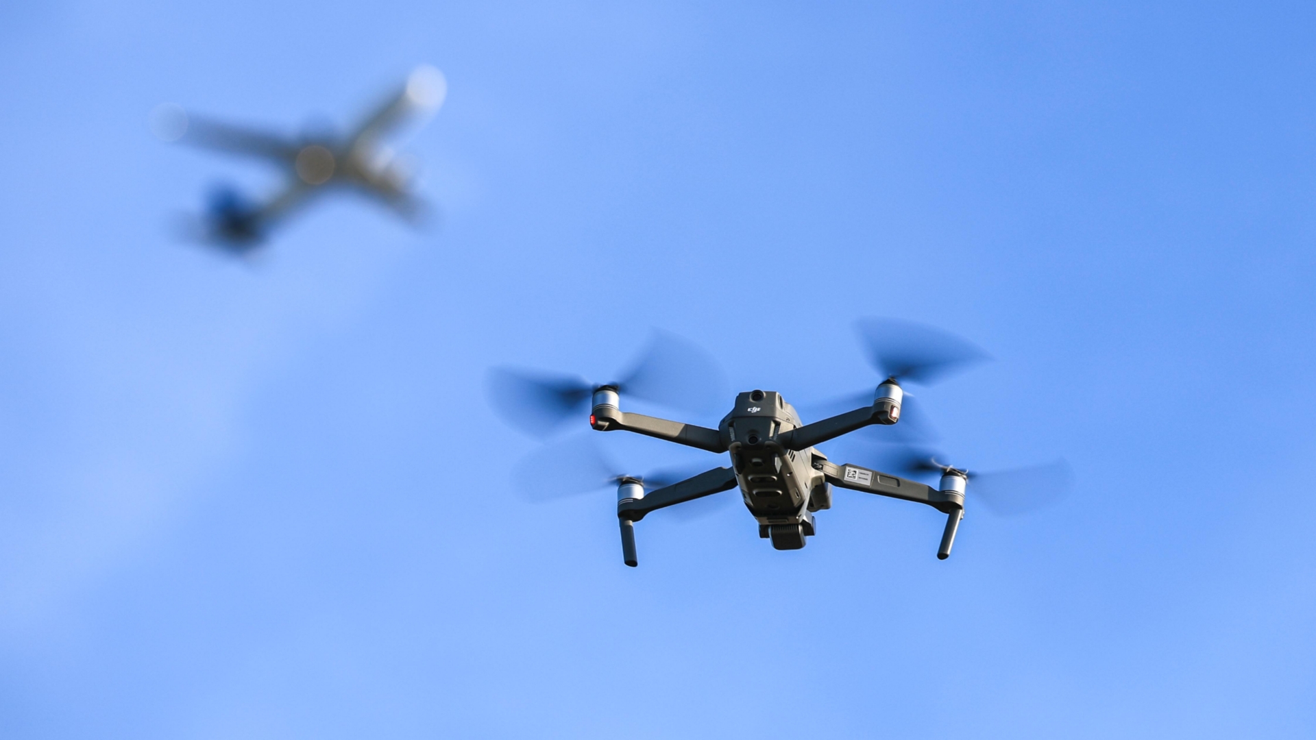 Drohne fliegt vor einem Flugzeug