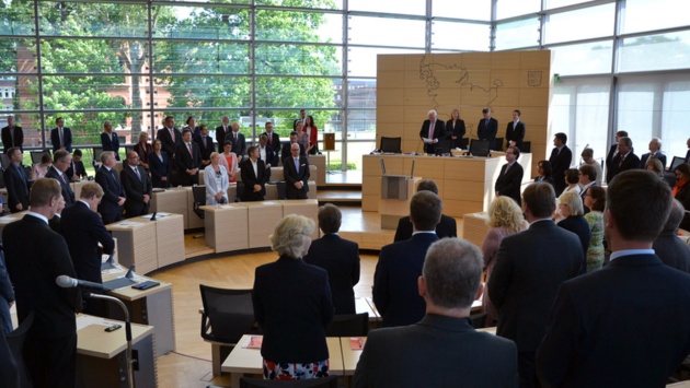 Die Abgeordneten erheben sich zum Gedenken von den Sitzen im Plenarsaal.