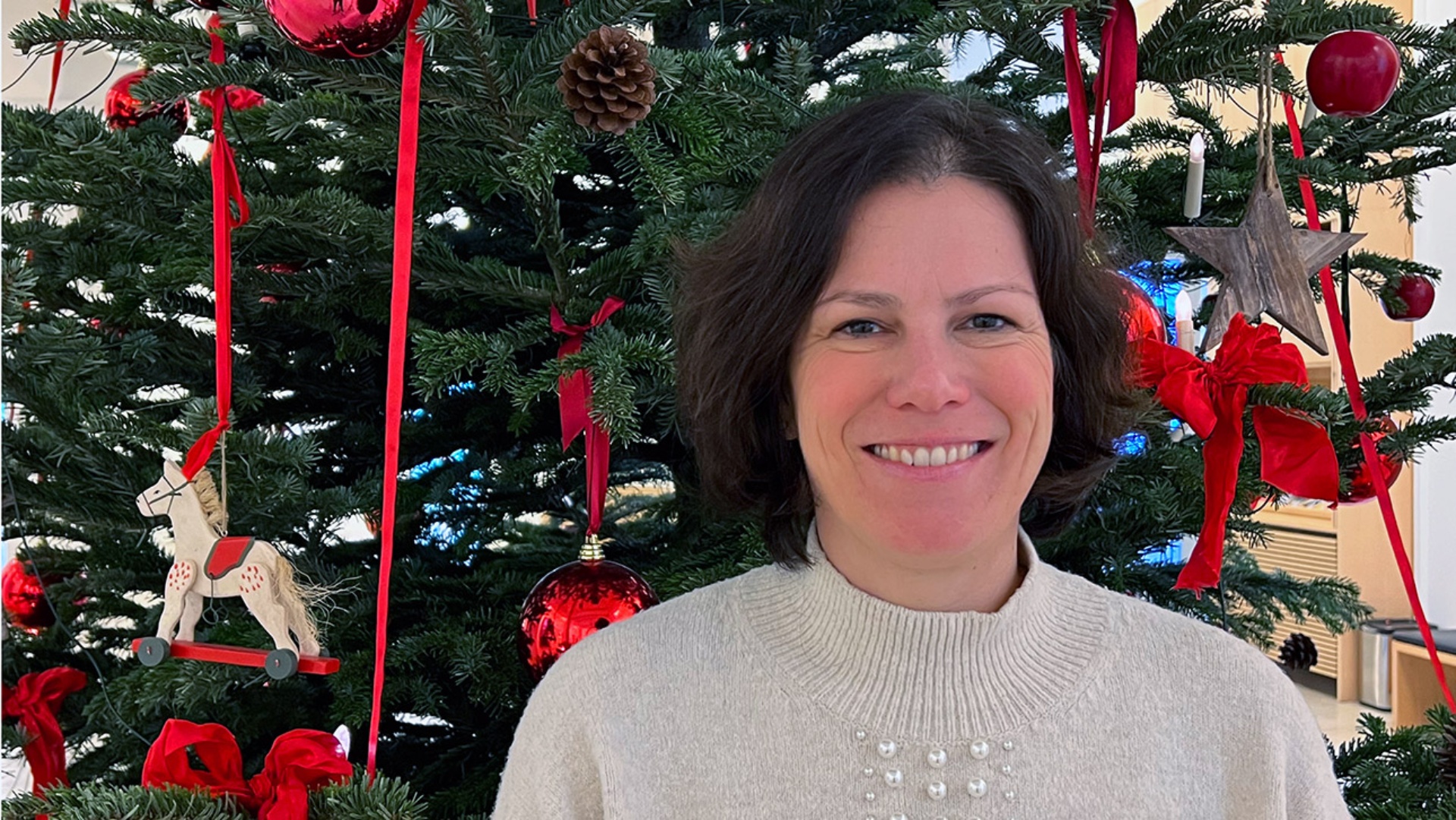 Porträt der Landtagspräsident Kristina Herbst vor einem bunt geschmückten Weihnachtsbaum