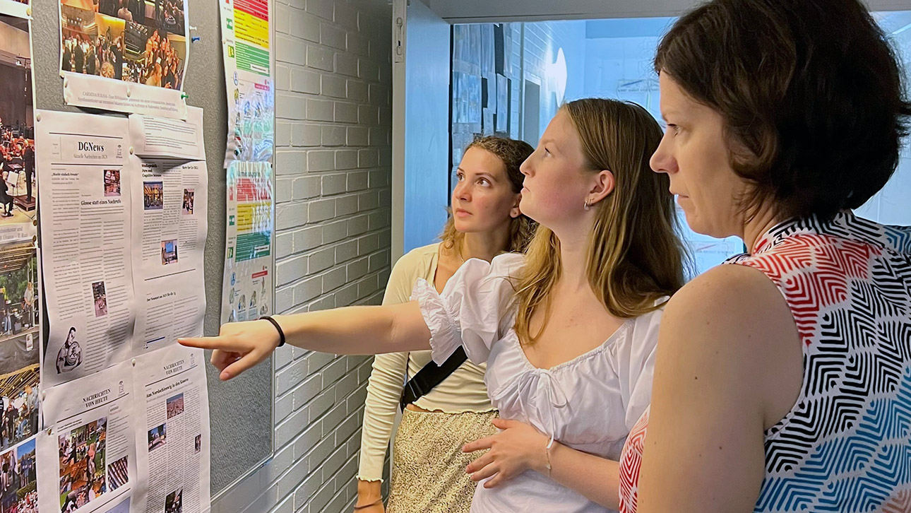 Zwei Schülerbotschafterinnen des Deutschen Gymnasiums für Nordschleswig in Apenrade erklären der Landtagspräsidentin Kristina Herbst etwas vor einer Tafel.  