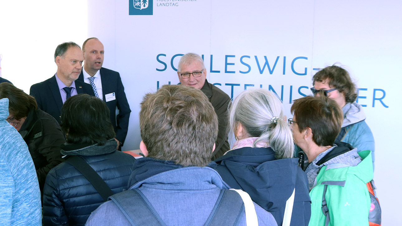 Landtagspräsident Klaus Schlie ist im vollgefüllten Messestand des Landtages im Gespräch mit Bürgern.