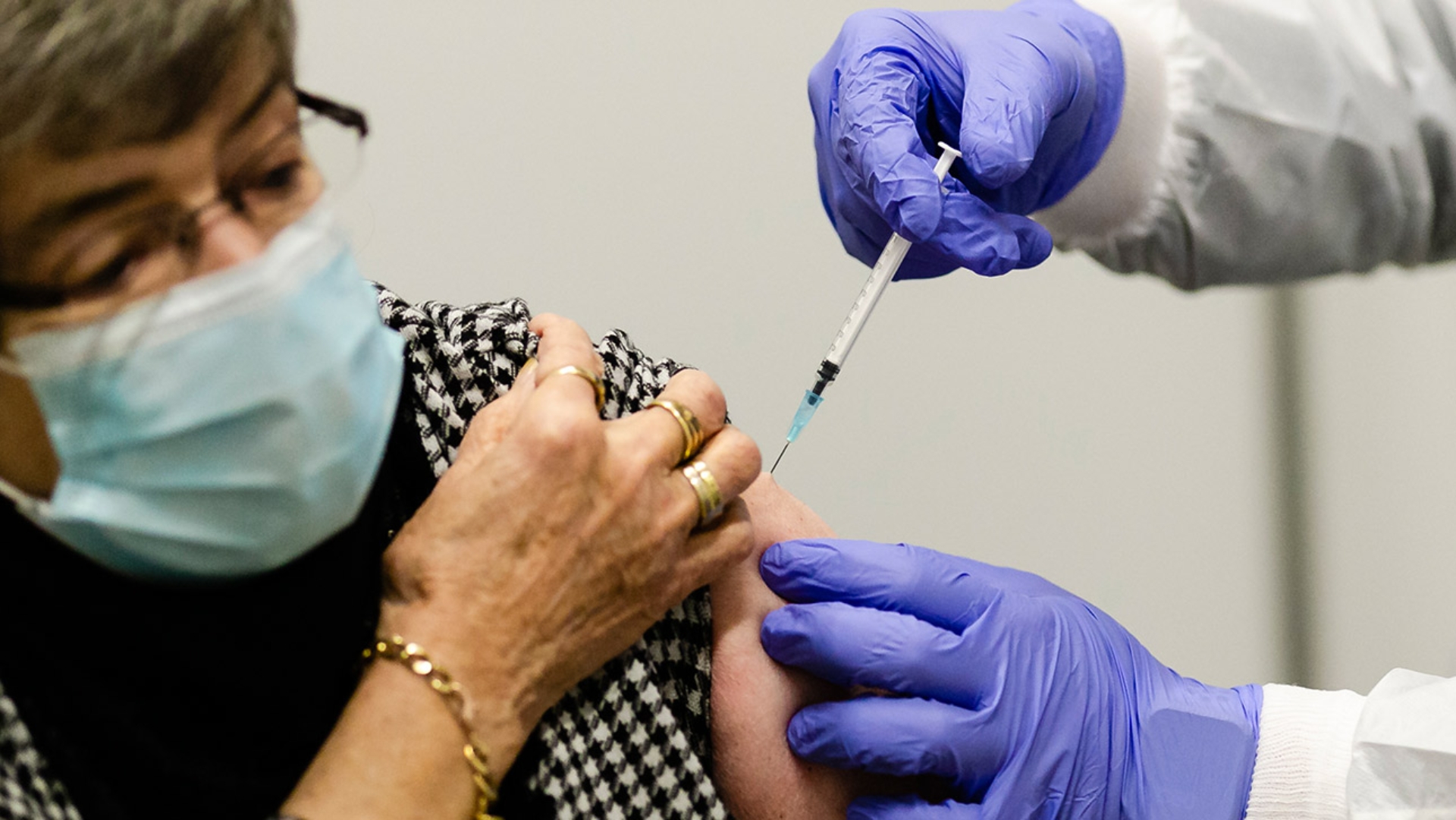 In den Arm einer Frau wird die Impfung gegen das Coronavirus injiziert.