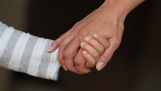 Eine Mutter hält ihr Kind an der Hand.