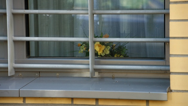 Ein Blumengesteck steht hinter einem vergitterten Fenster des Maßregelvollzugs des Landeskrankenhauses Bernburg.