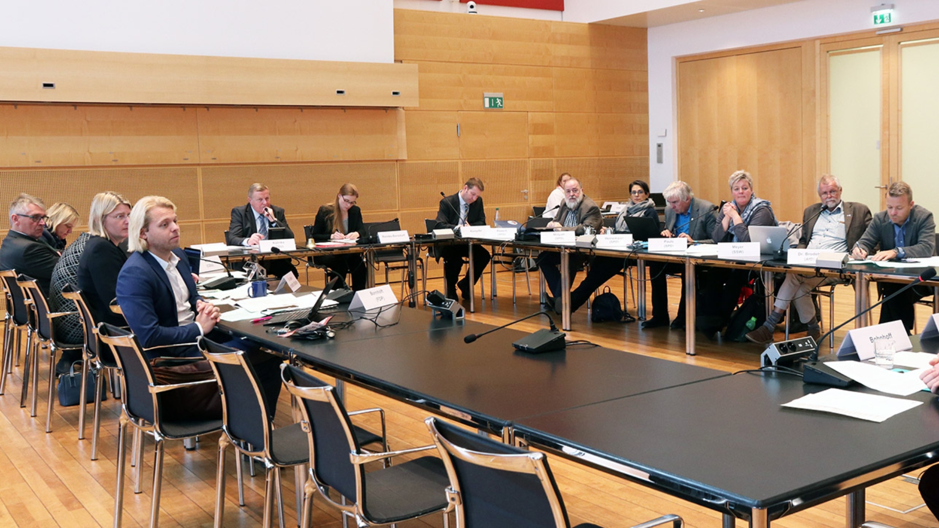 Die Mitglieder des Sozialausschuss sitzen in einem Ausschusssaal des Landtages an U-förmig aufgestellten Tischen. 