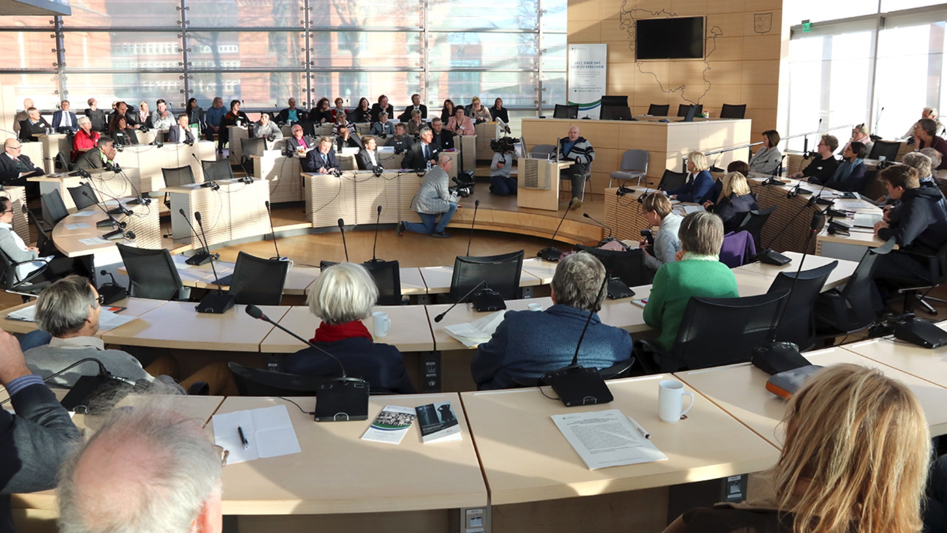 Ein Betroffener von Missbrauch in Kinderheimen spricht vor Politikern und weiteren Gästen im Plenarsaal.