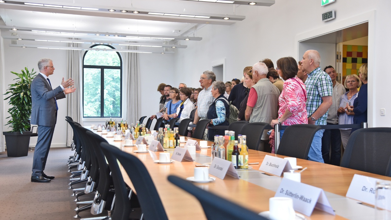Besucher lauschen einer Erklärung zu einem Fraktionsraum beim Tag der offenen Tür im Landtag Schleswig-Holstein