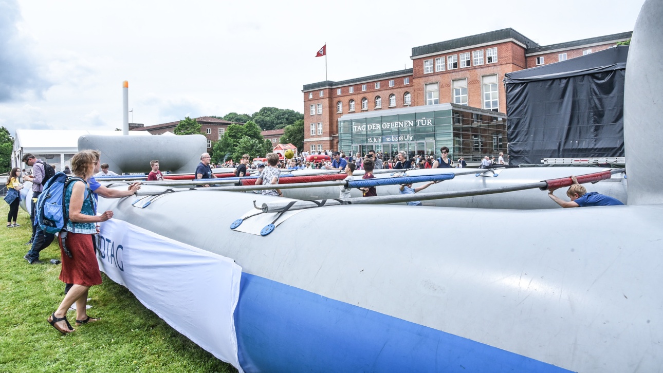 Besucher spielen in einem aufblasbaren Superkicker auf der Wiese vor dem Plenarsaal beim Tag der offenen Tür im Landtag Schleswig-Holstein