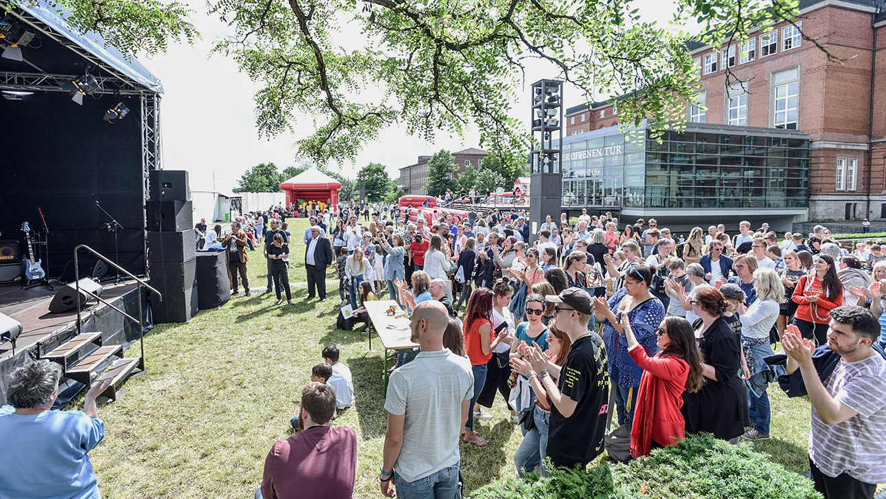 Menschen stehen vor der Bühne auf dem Rasen vor dem Landeshaus beim Tag der offenen Tür