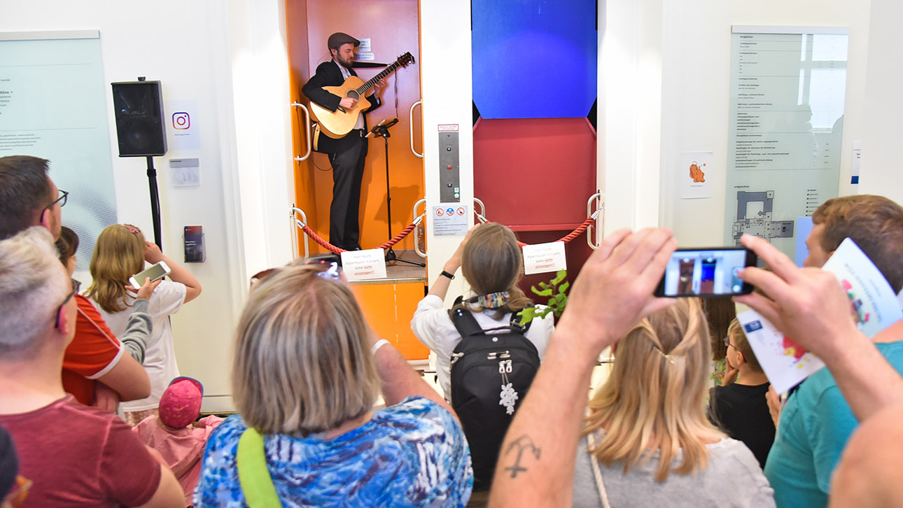 Besucher lauschen Musikern im Paternoster beim Tag der offenen Tür