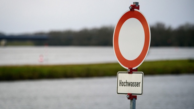 Ein Schild weist auf Hochwasser an der Elbe hin.