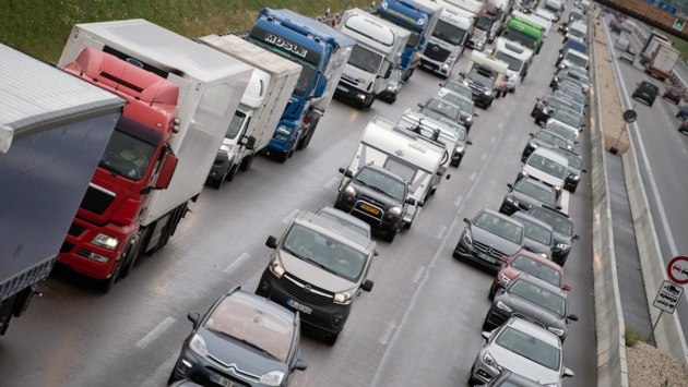 Lastwagen und Autos stehen auf einer Autobahn dichtgedrängt im Stau.