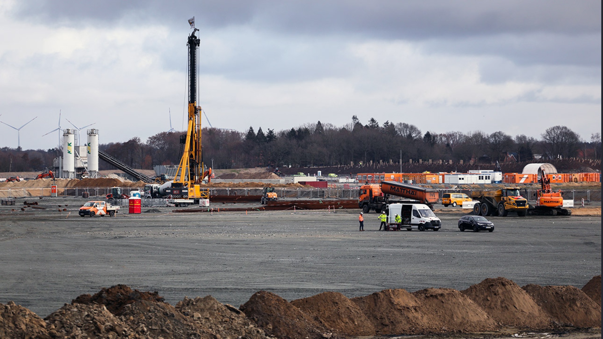 Blick auf die Baustelle der Batteriezellenfabrik von Northvolt in Heide, wo Baufahrzeuge fahren und Arbeiter tätig sind.
